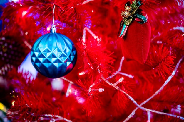 Bolas de decoração de Natal penduradas em galhos de pinheiros, guirlandas e ornamentos de árvore de Natal