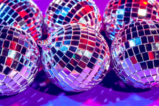 Bolas de discoteca pequenas brilhantes brilhando em uma bela luz roxa. conceito de festa discoteca