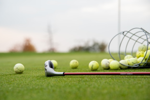 Bolas de golfe e paus no campo de golfe verde