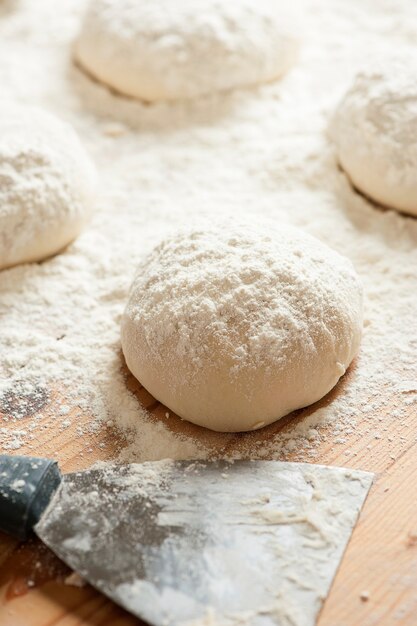 Bolas de massa cobertas com farinha de trigo prontas para assar