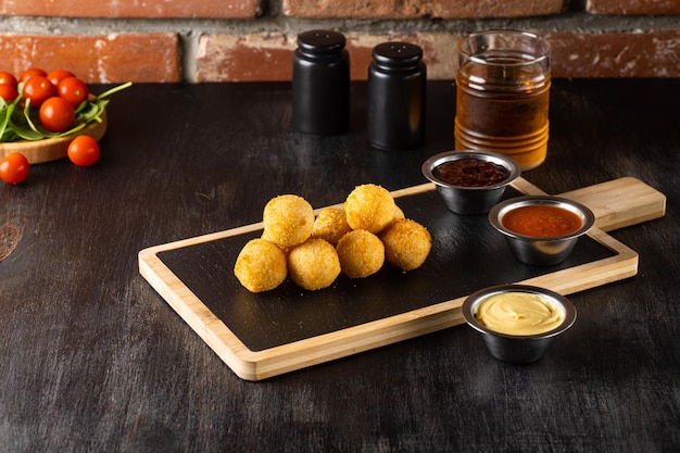 Bolas de mozarella derretidas fritas quentes em fundo de madeira