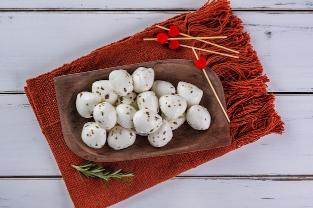 Foto bolas de mussarela de búfala polvilhadas com orégano em uma bandeja de madeira