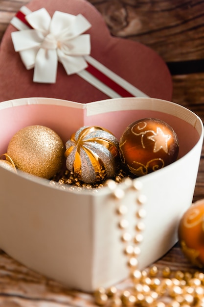 Bolas de Natal coloridas em uma caixa em forma de um coração. Decorações de Natal. Ano Novo.