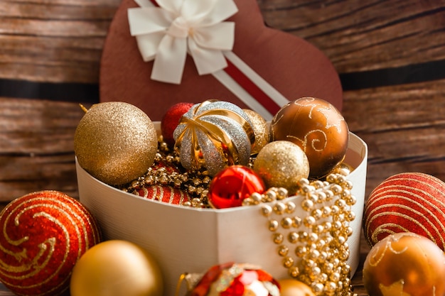 Bolas de Natal coloridas em uma caixa em forma de um coração. Decorações de Natal. Ano Novo.