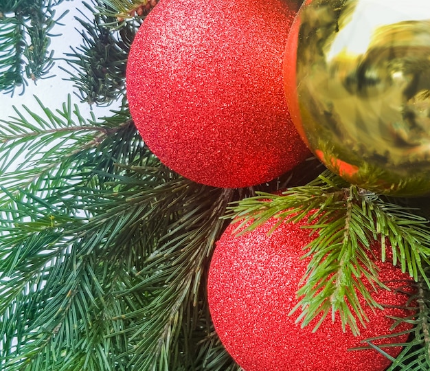 Foto bolas de natal douradas e vermelhas em close-up da árvore de natal. decorar a casa de um ano novo