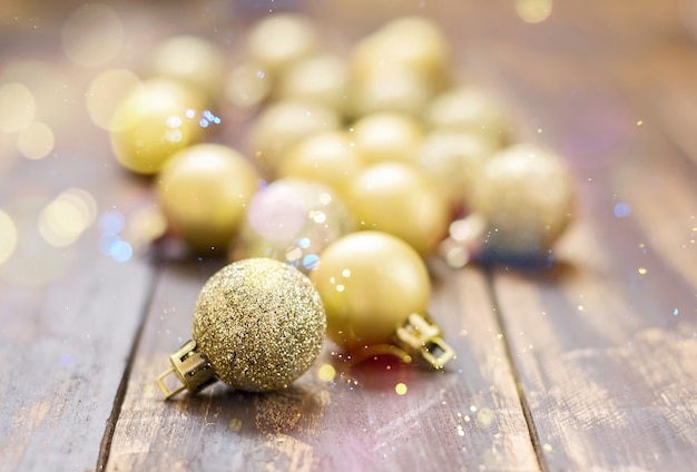 Bolas de Natal dourado brilhavam na mesa de madeira marrom.