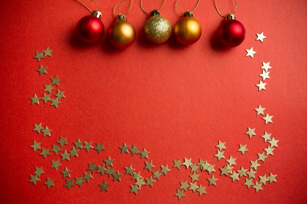 Bolas de Natal e estrelas para decorar em um fundo vermelho Ano Novo