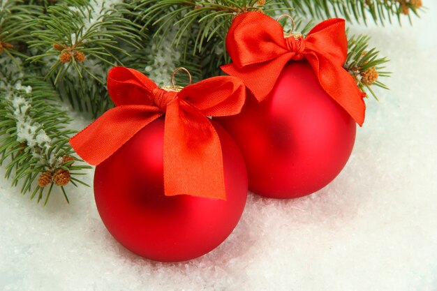 Bolas de Natal na árvore do abeto com neve, isoladas no branco