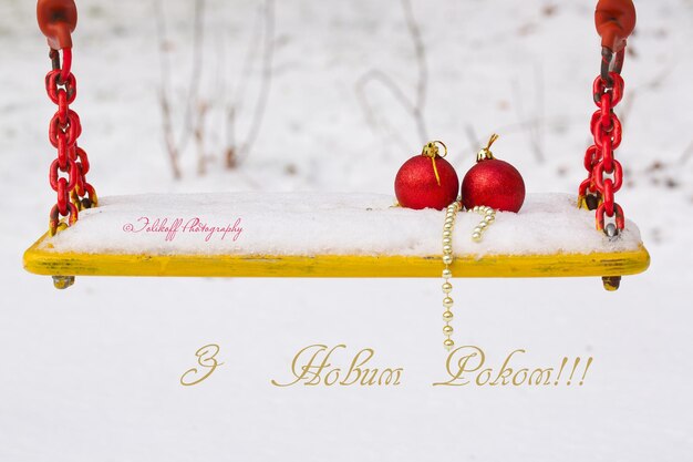 Bolas de Natal na neve em um assento de balanço