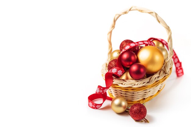 Bolas de natal vermelhas e douradas em uma pequena cesta