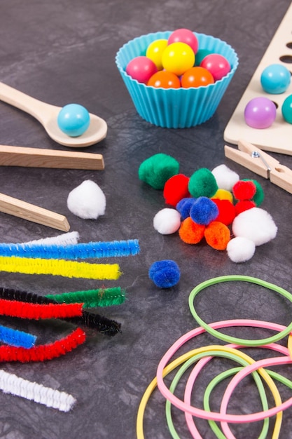 Bolas de pompons coloridos e borrachas de borracha com colher e pinça Desenvolvimento de habilidades motoras infantis coordenação criatividade e raciocínio lógico