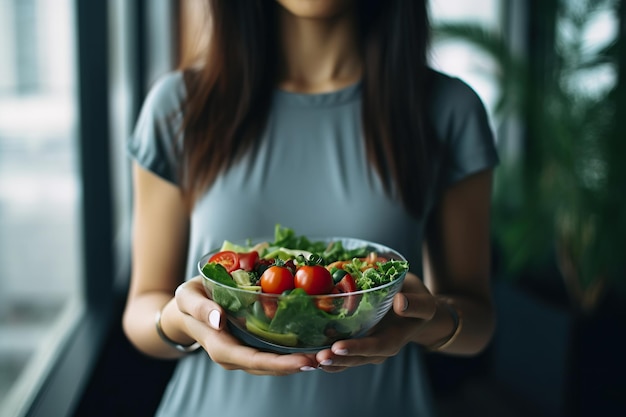 Bolas de salada saudáveis mantidas por mulheres asiáticas em roupas de ginástica para promover boa saúde e bem-estar