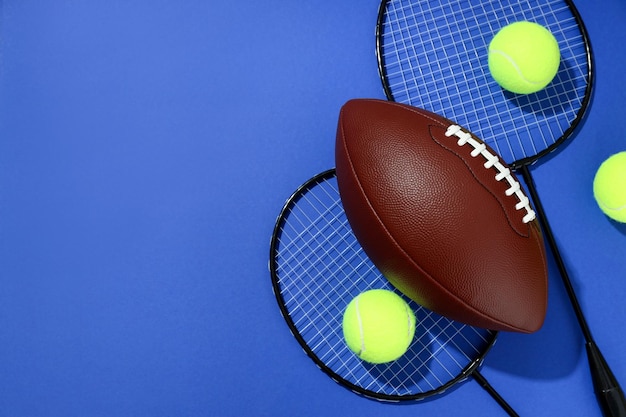 Bolas de tênis de raquetes de badminton e bola de basquete em fundo azul