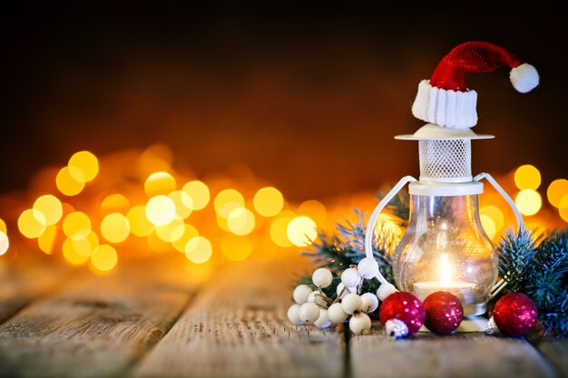 Bolas de vela e natal em uma mesa de madeira no fundo de uma guirlanda. bokeh .