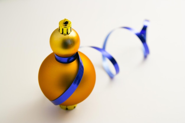 Bolas de decoración navideña dorada con lazo de cinta azul aislado sobre fondo blanco