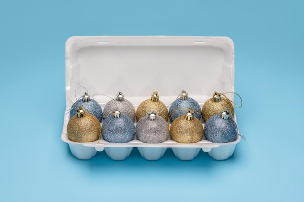 Bolas, decorações de Natal brilhantes, em uma caixa de ovos branca. Férias de inverno, feliz natal. Estúdio