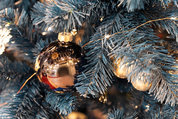 Bolas douradas no galho da árvore de Natal decorações de natal Brinquedos e luzes festivas da árvore de Natal