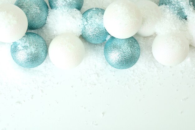 Bolas e neve decorativa na mesa branca