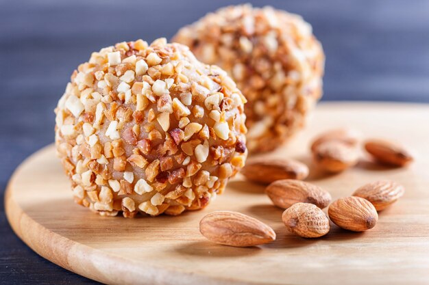 Las bolas de la energía se apelmazan con las almendras en el tablero de madera en negro