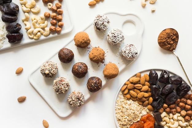 Bolas de energía con cacao y nueces en blanco.