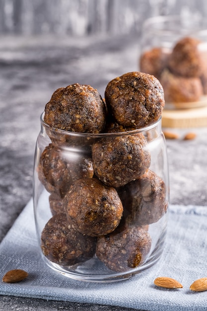 Bolas de energía de frutos secos y nueces en un frasco de vidrio, enfoque selectivo en el fondo.