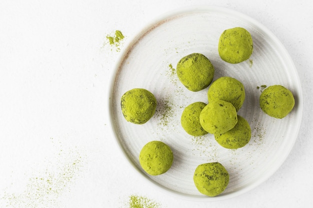 Bolas de energía Matcha en un plato blanco sobre un blanco