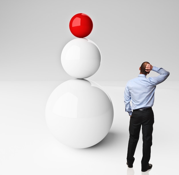 bolas equilibradas y hombre pensante aislado en blanco