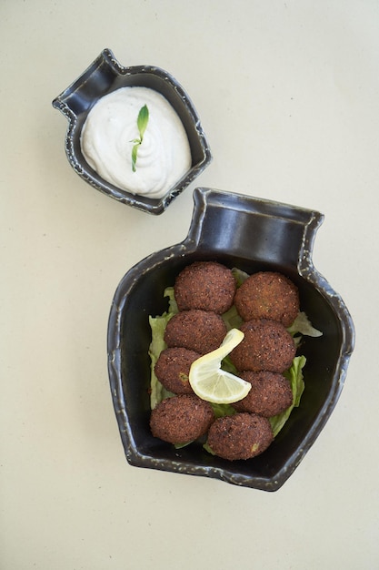 Bolas de falafel con salsa tzatziki en plato negro