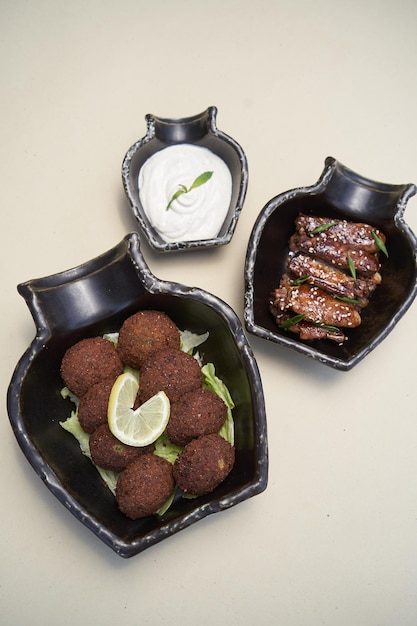 Bolas de falafel con salsa tzatziki en plato negro