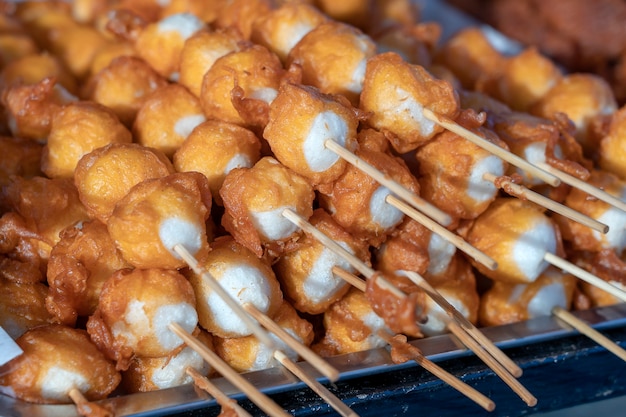 Bolas fritas en grasa profunda con palos, comida estilo tailandés. Comida rápida callejera en Tailandia, cerrar