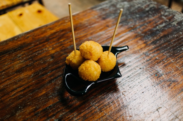 Foto las bolas fritas del queso sirvieron en la tabla de madera en el café.