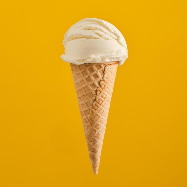 Bolas de helado en cono de galleta aislado sobre fondo amarillo. Cucurucho de helado.