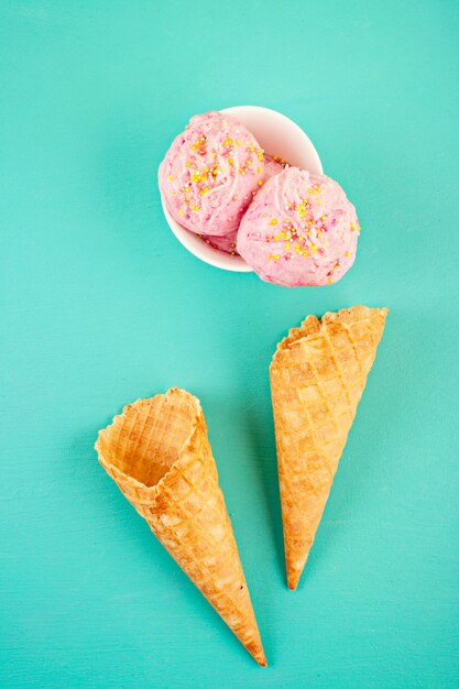 Bolas de helado de fresa en un tazón blanco con cobertura