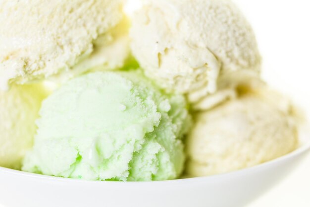 Bolas de helado de vainilla y lima en una taza blanca.