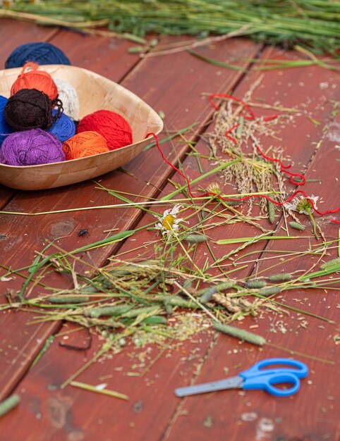 Bolas de hilo de lana para tejer en una mesa de madera tejer en la naturaleza costura en el jardín