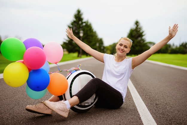 Bolas infláveis. mulher senta-se com monowheel na estrada.