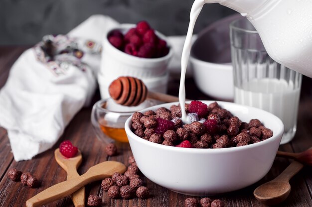 Bolas de maíz desayuno con leche que se vierte sobre él