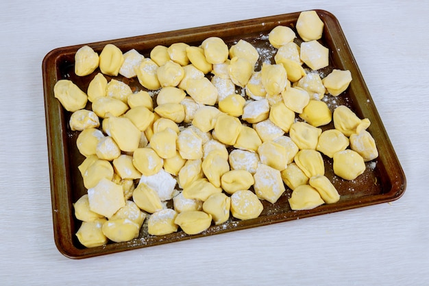 Bolas de masa hervida crudas en una tabla de madera. Comida casera tradicional. El proceso de cocinar albóndigas.