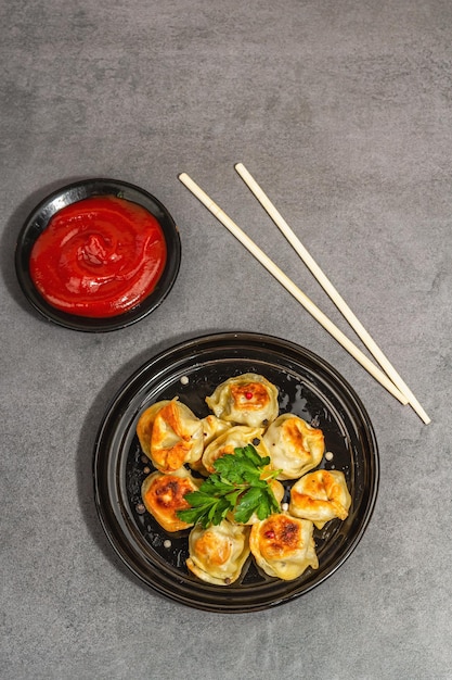 Bolas de masa hervida fritas con salsa de tomate y mezcla de pimientos Comida vegana sombra oscura de luz dura moderna