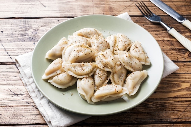 Bolas de masa hervida, rellenas de carne, ravioles. Plato tradicional ruso pelmeni. Bolas de masa hervida con relleno horizontal