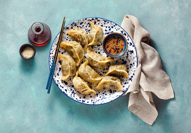 Bolas de masa hervida wonton con salsa picante de sésamo en la mesa.