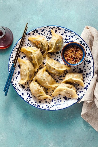 Bolas de masa hervida wonton con salsa picante de sésamo en la mesa.