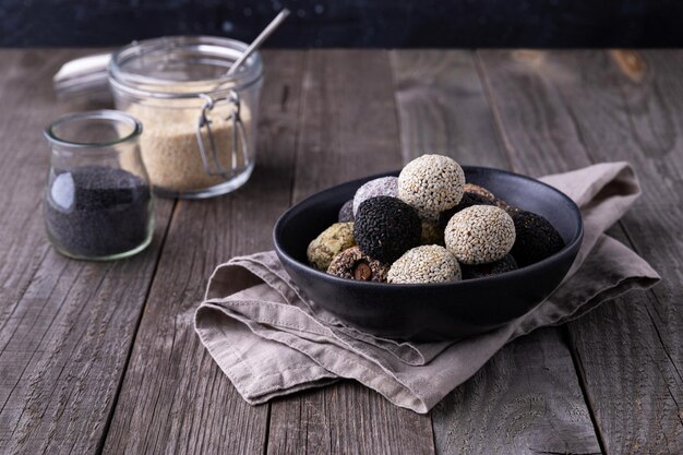 Bolas de mordiscos de energía cruda preparadas con ingredientes naturales sobre fondo de madera