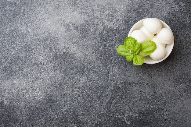 Bolas de mozzarella y albahaca en el plato, enfoque selectivo copiar espacio