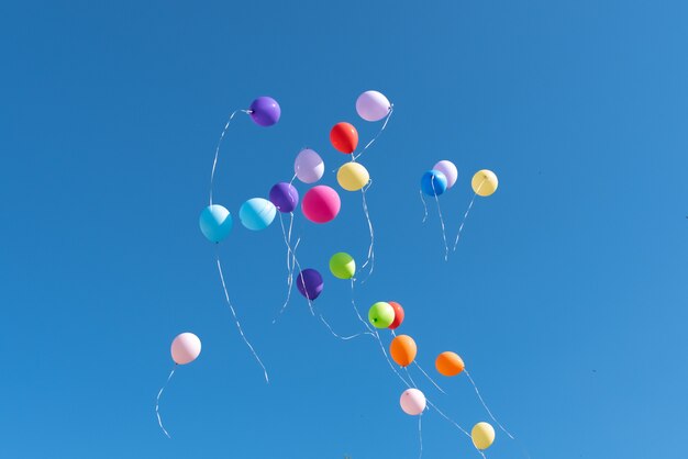 Bolas multicolores lanzadas al cielo azul