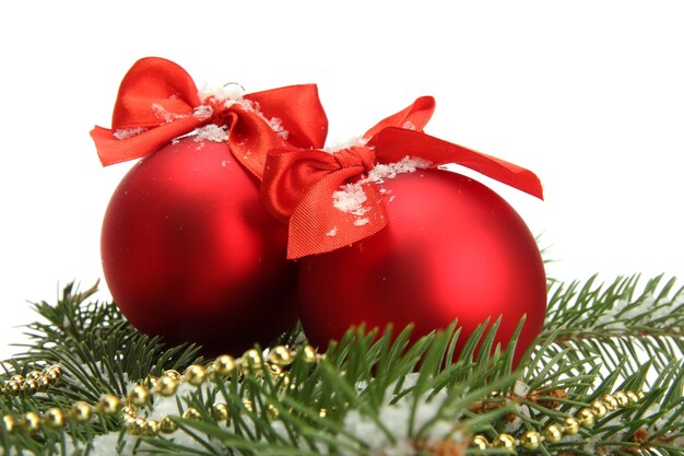 Bolas de Navidad en abeto con nieve, aislado en blanco