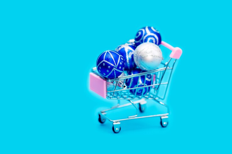 Foto las bolas de navidad azules se apilan en un pequeño carro de compras.