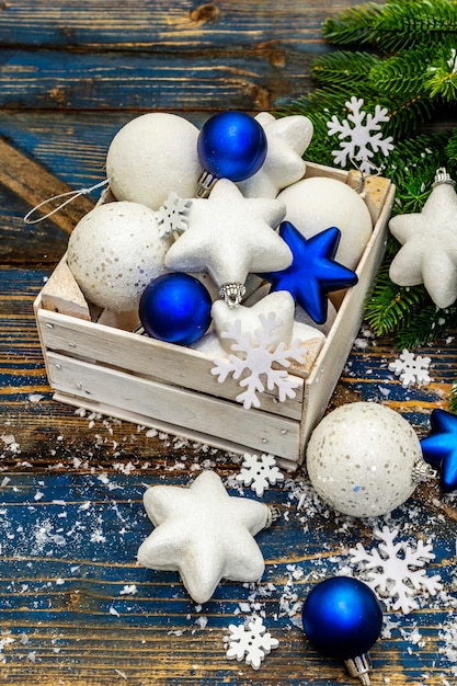 Bolas de Navidad blancas y azules y estrellas, ramas de abeto y copos de nieve. de cerca