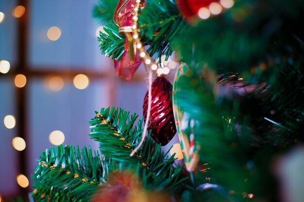 Bolas de Navidad brillantes colgando de ramas de pino con fondo festivo