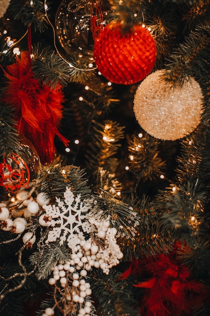 Bolas de Navidad brillantes doradas y rojas colgando del árbol de Navidad Efecto mágico de la guirnalda Bokeh